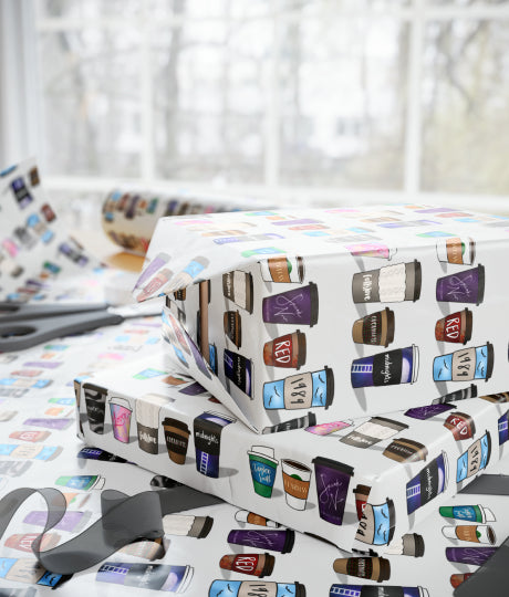 gifts wrapped in white paper with the sunshine and snow coffee cups printed